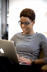 a woman sitting in front of a laptop computer