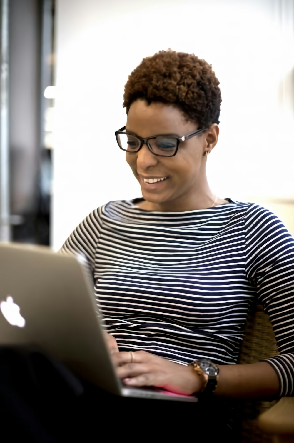 a woman sitting in front of a laptop computer