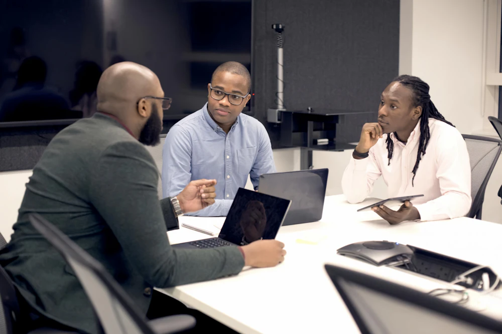 Three colleagues reviewing papers at a meeting table