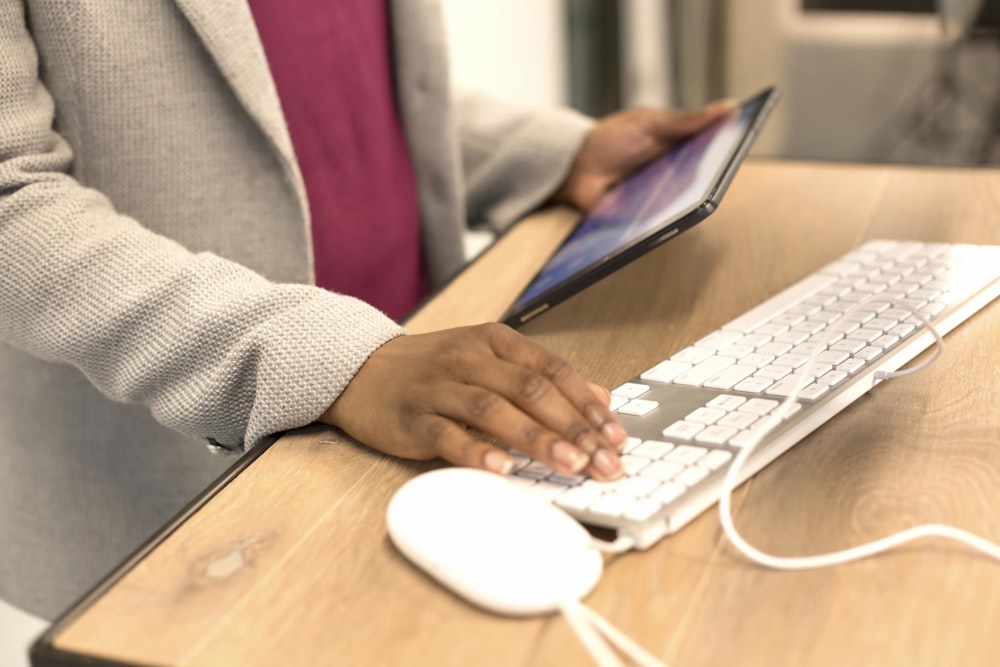 a person sitting at a desk with a keyboard and mouse