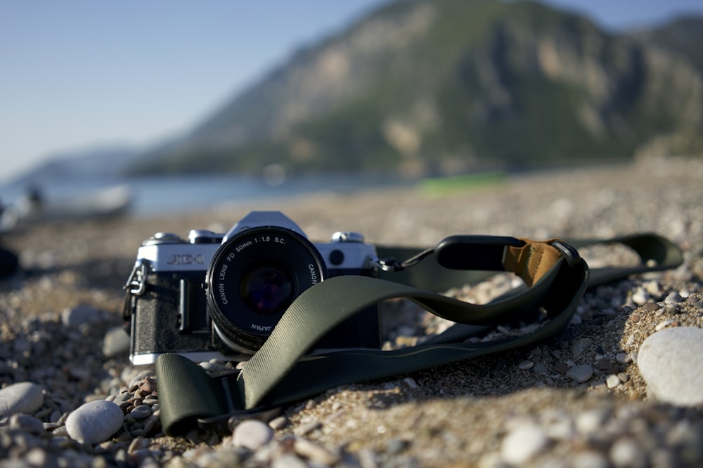 a camera sitting on the ground with a strap around it