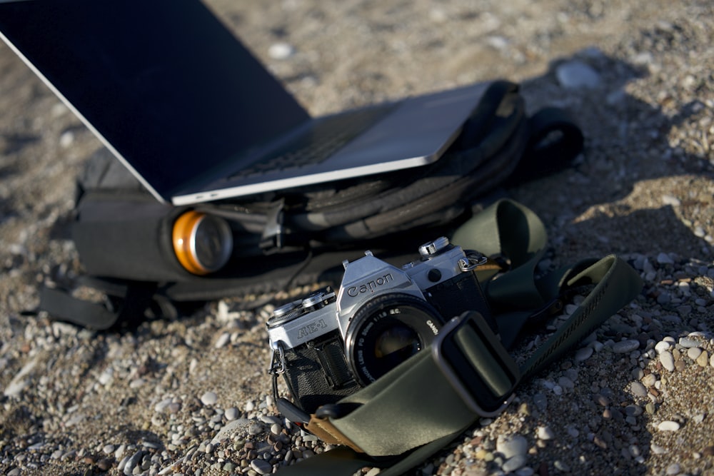 a camera and a laptop on the ground