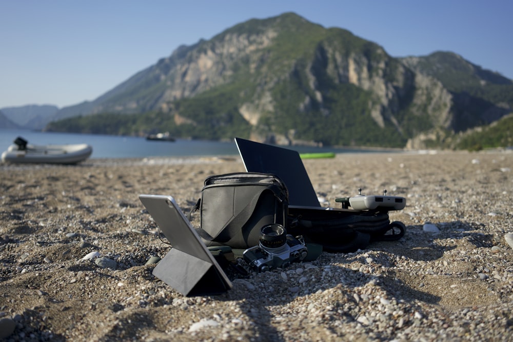 un computer portatile seduto sulla cima di una spiaggia sabbiosa