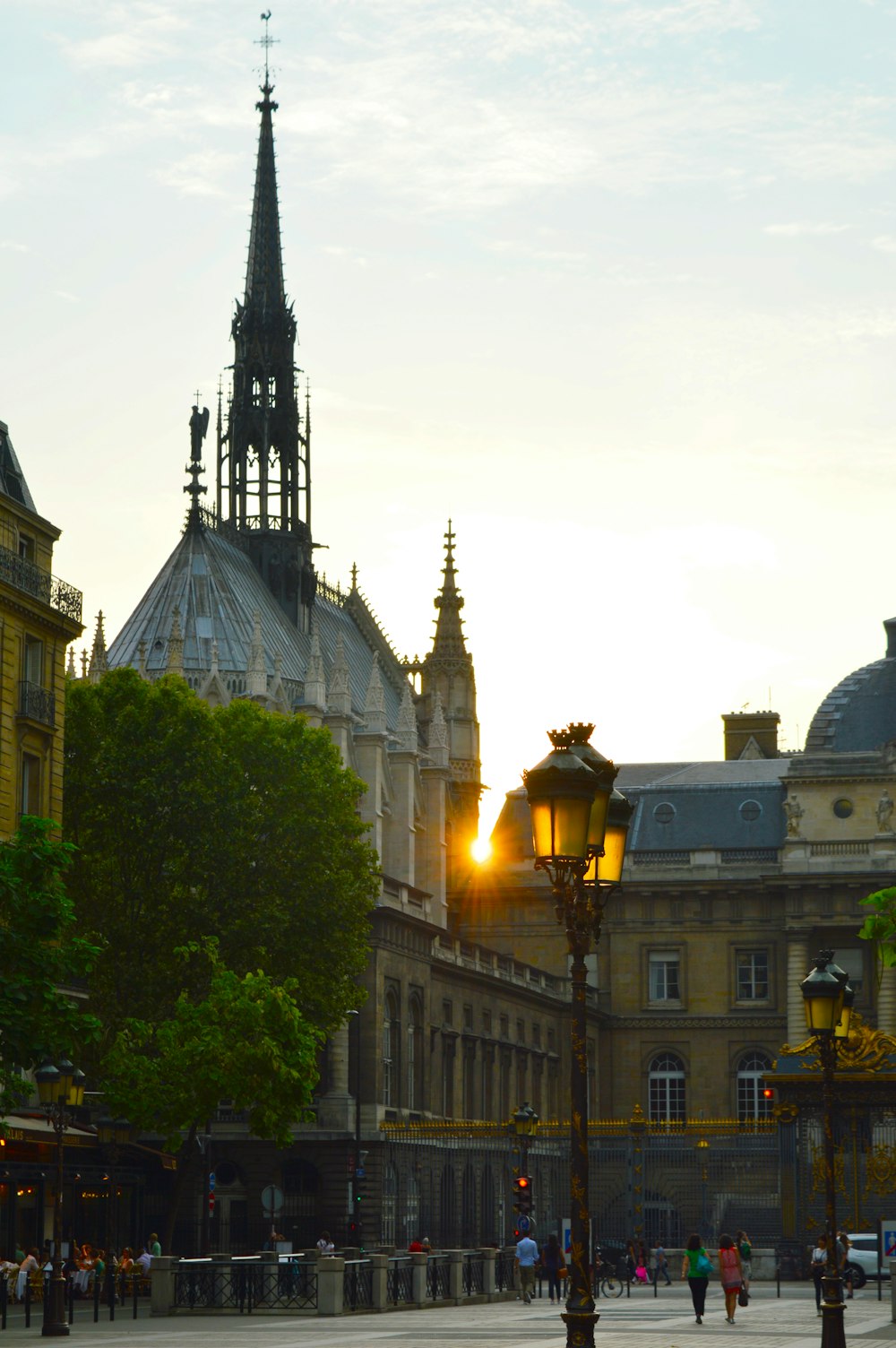 the sun is setting behind a building with a clock tower