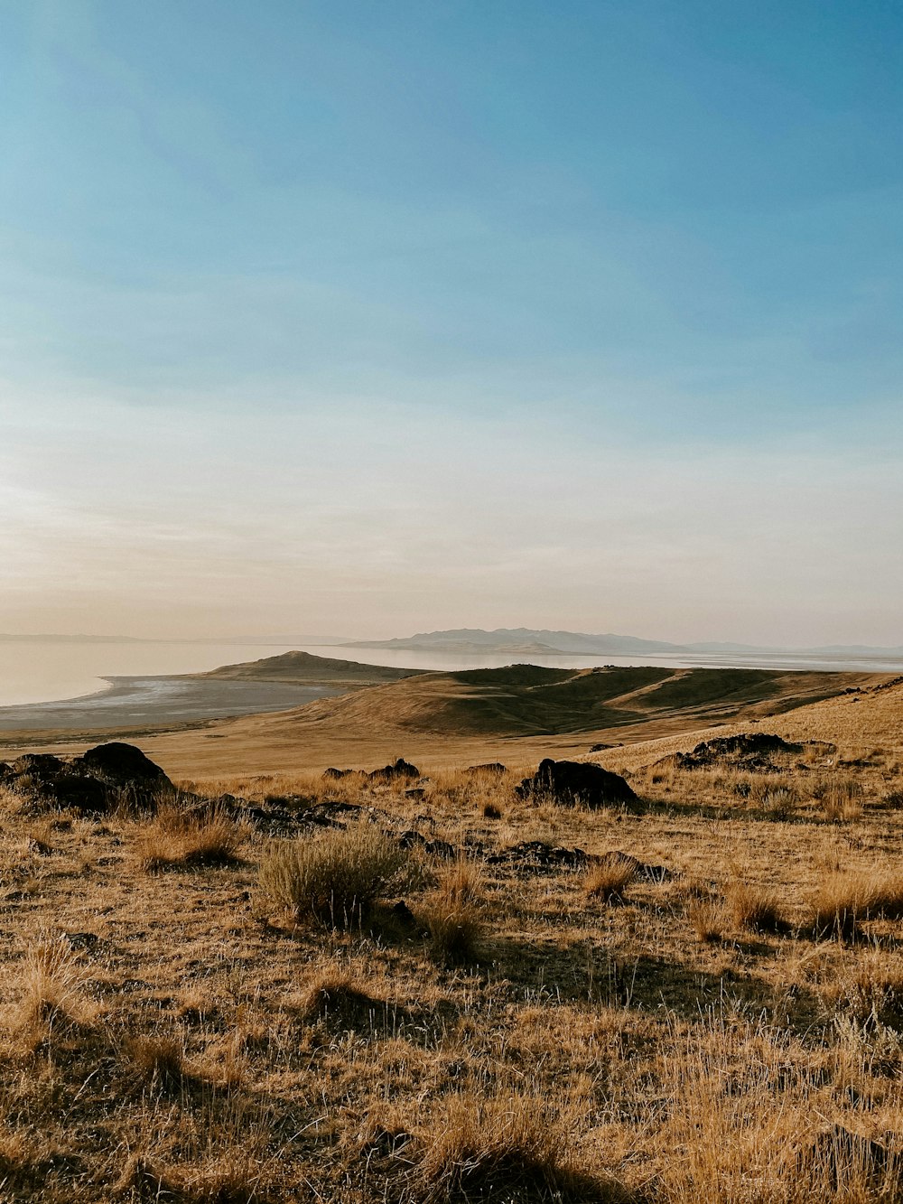 a grassy field with hills in the distance