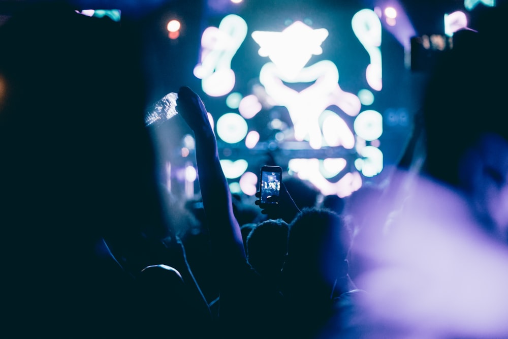 a crowd of people at a concert with their cell phones
