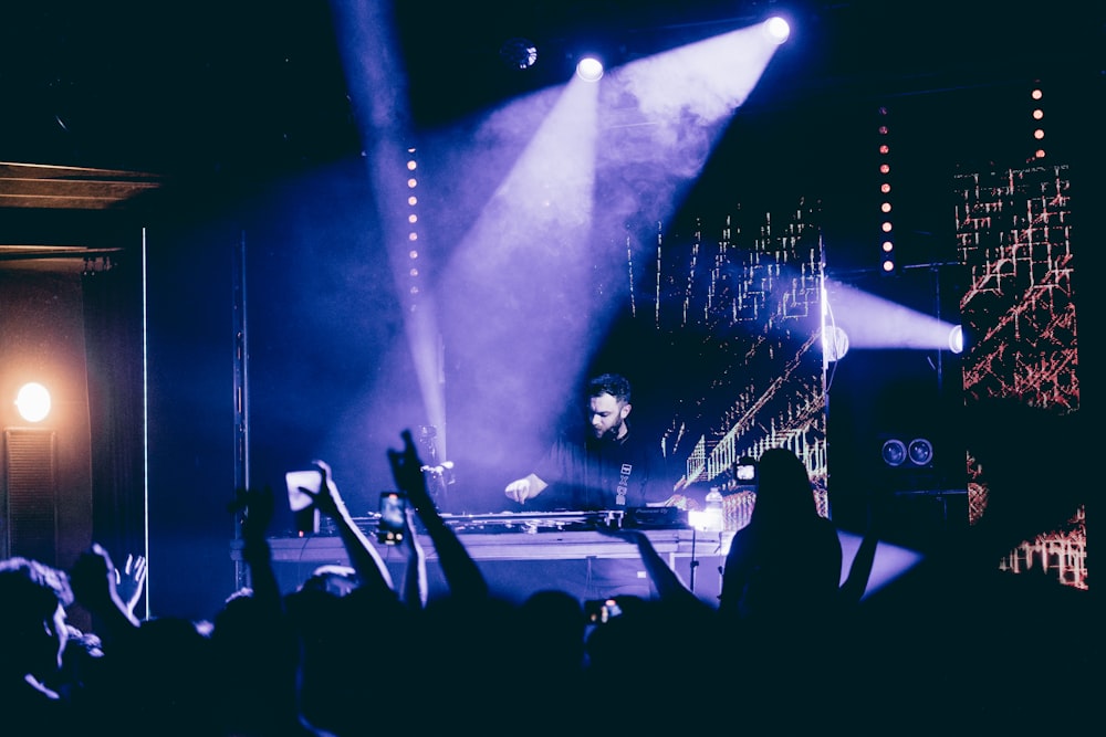 a man standing on a stage in front of a crowd