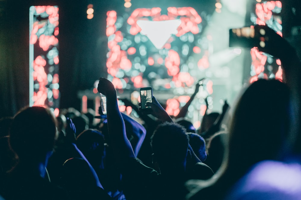 a crowd of people taking pictures of a stage