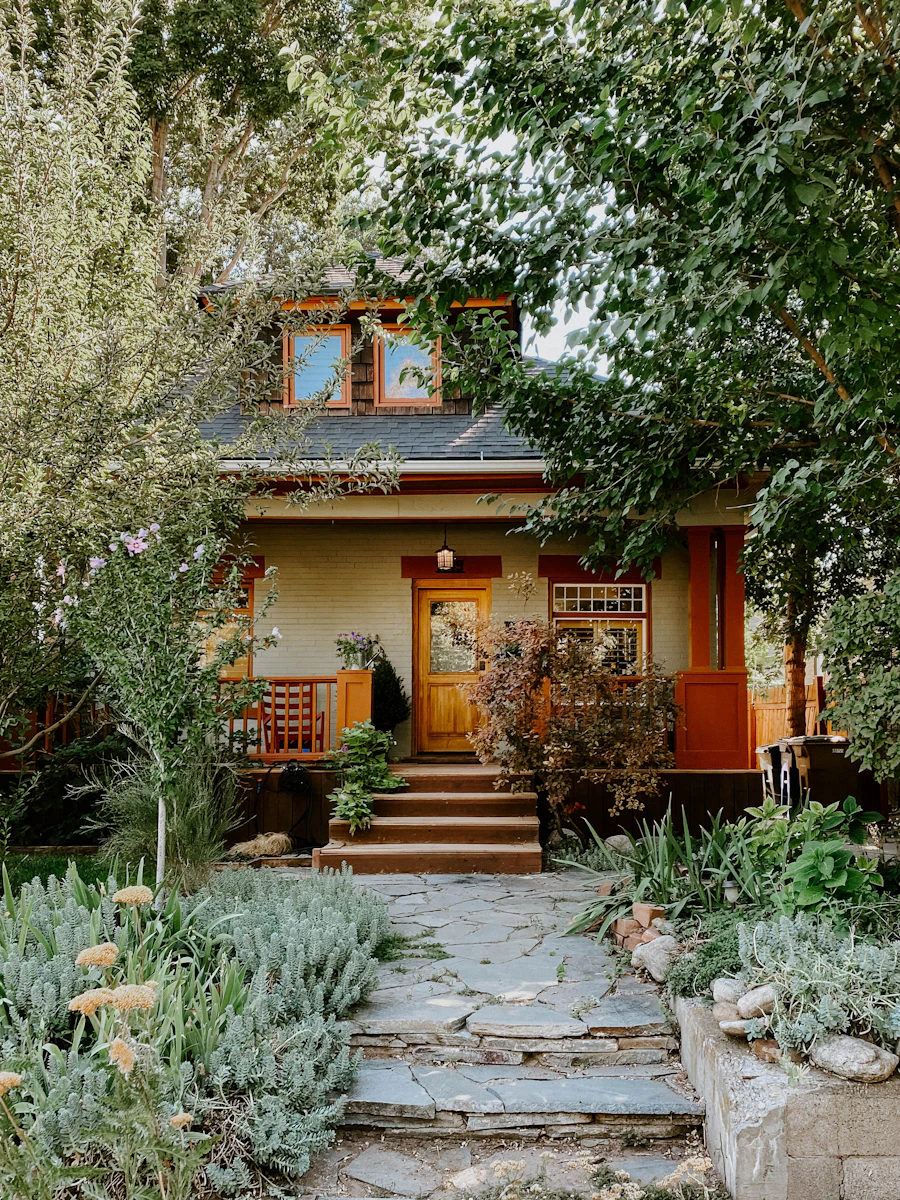 Bungalow with a stone path leading through a green garden to the front door