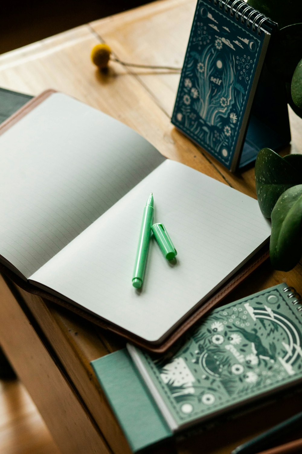 a notebook with a green pen on top of it