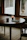 Sunlit room with runes scattered over a wooden table, next to an open journal and crystal stones.