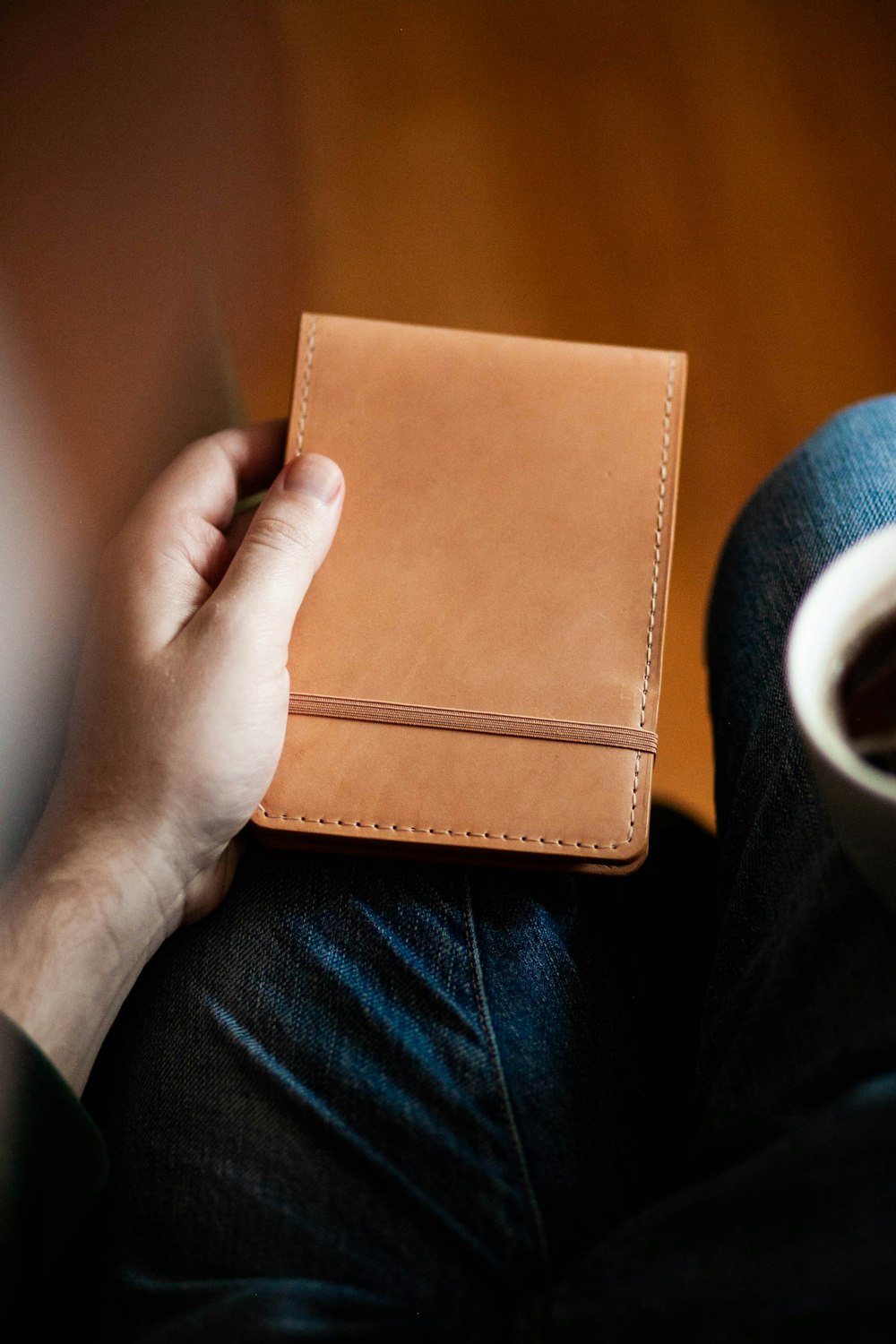 a person holding a brown leather wallet