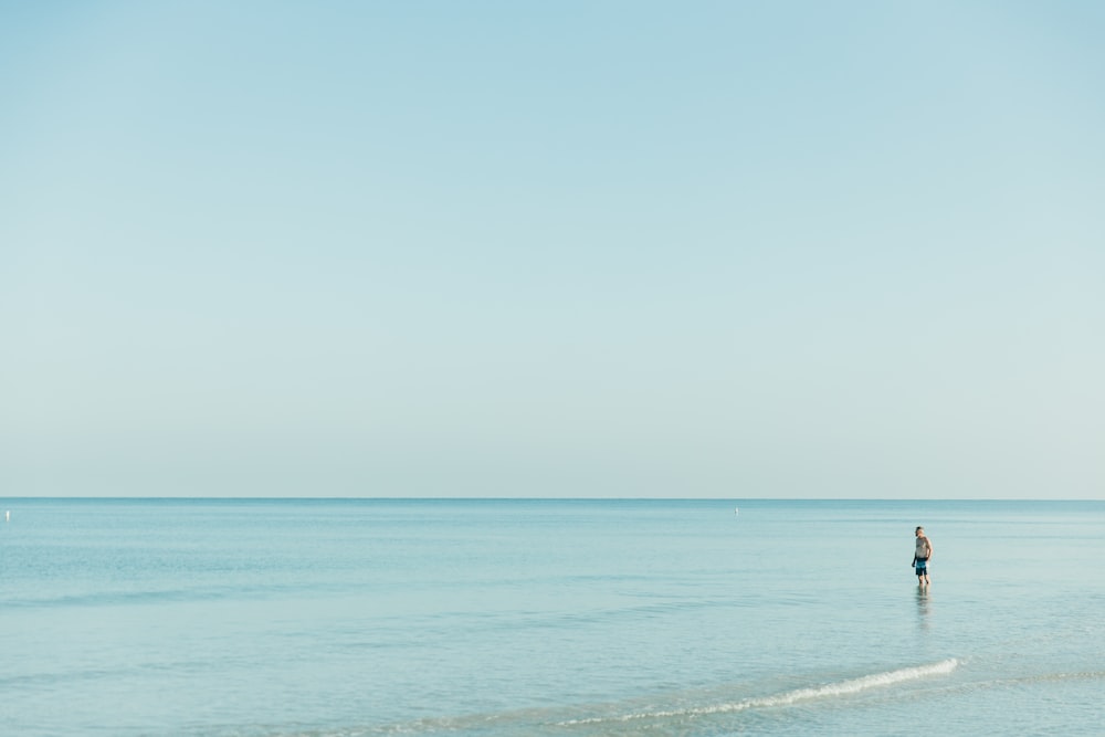 a person standing in the water on a beach