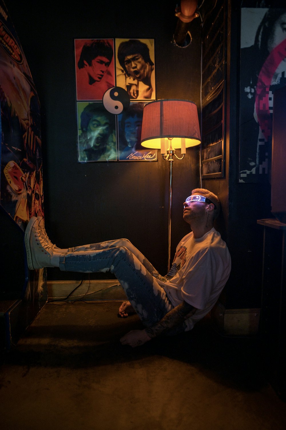 a man sitting on the floor in a room with a lamp