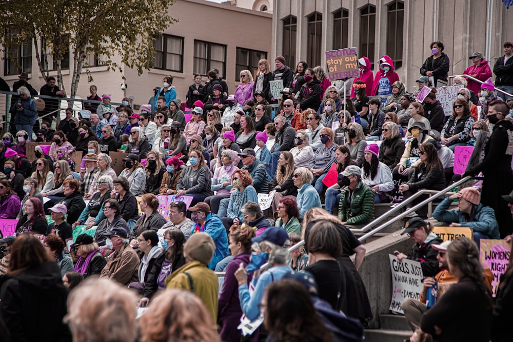 a crowd of people sitting on the steps of a building