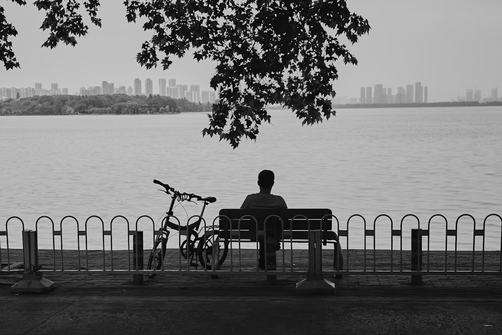 a man sitting on a bench next to a bike