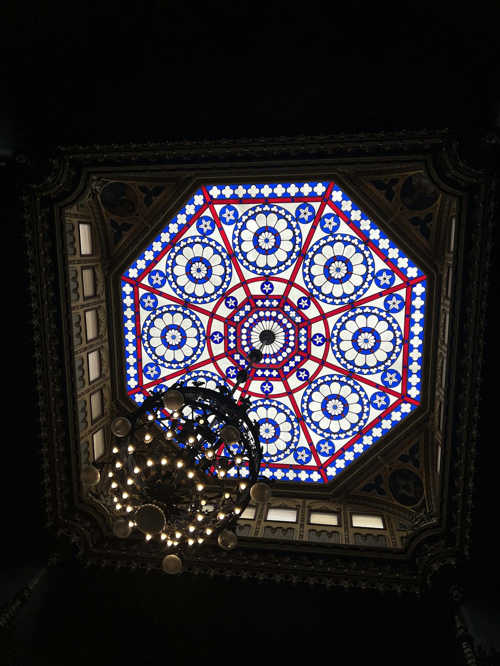 the ceiling of a building with a circular stained glass window