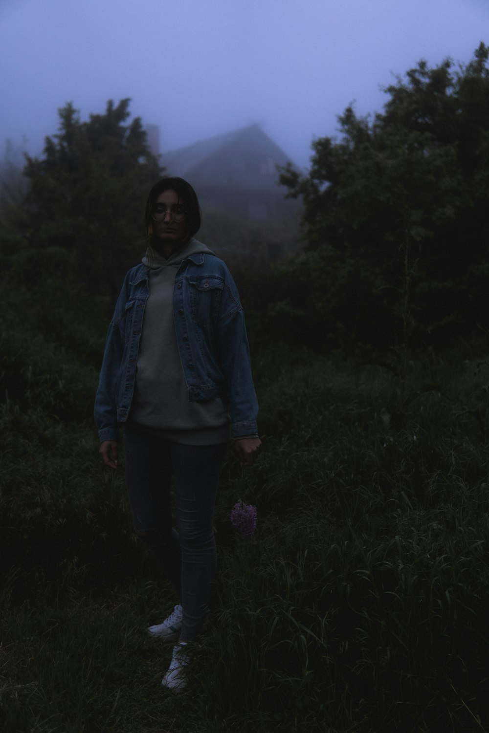 a person standing in a field with trees in the background