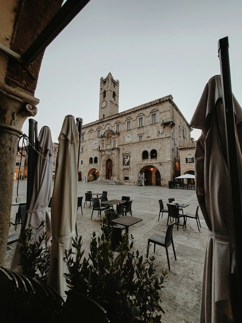 a large building with tables and chairs in front of it