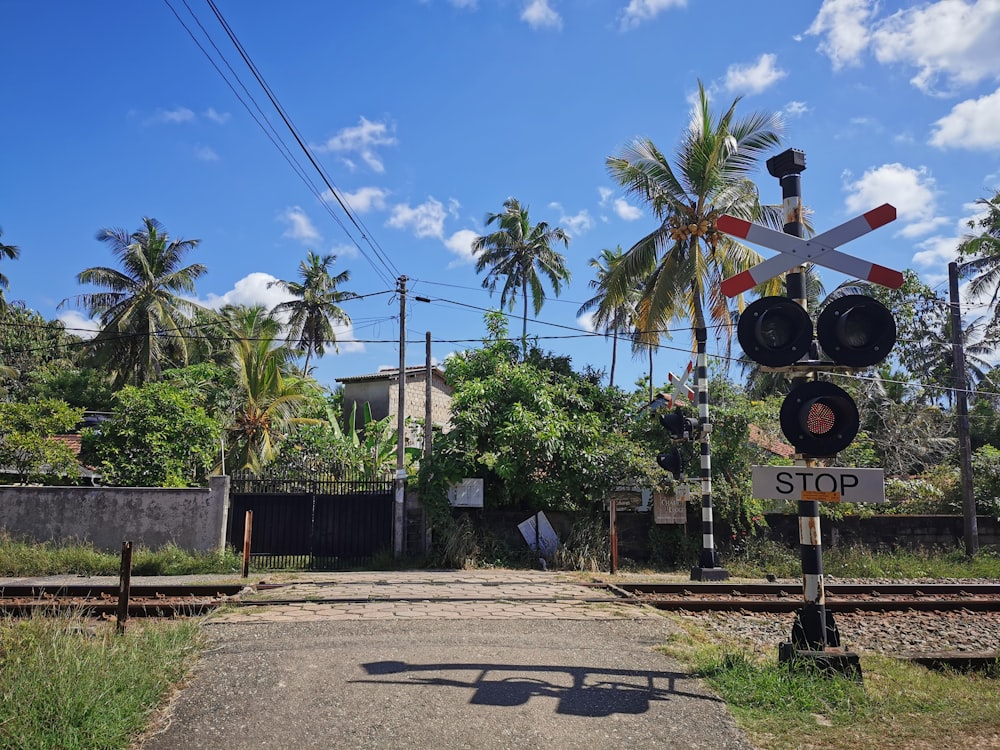 un cruce de ferrocarril con una señal de alto y vías de ferrocarril