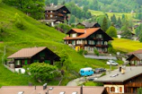 a group of houses on a hillside with cars parked in front of them