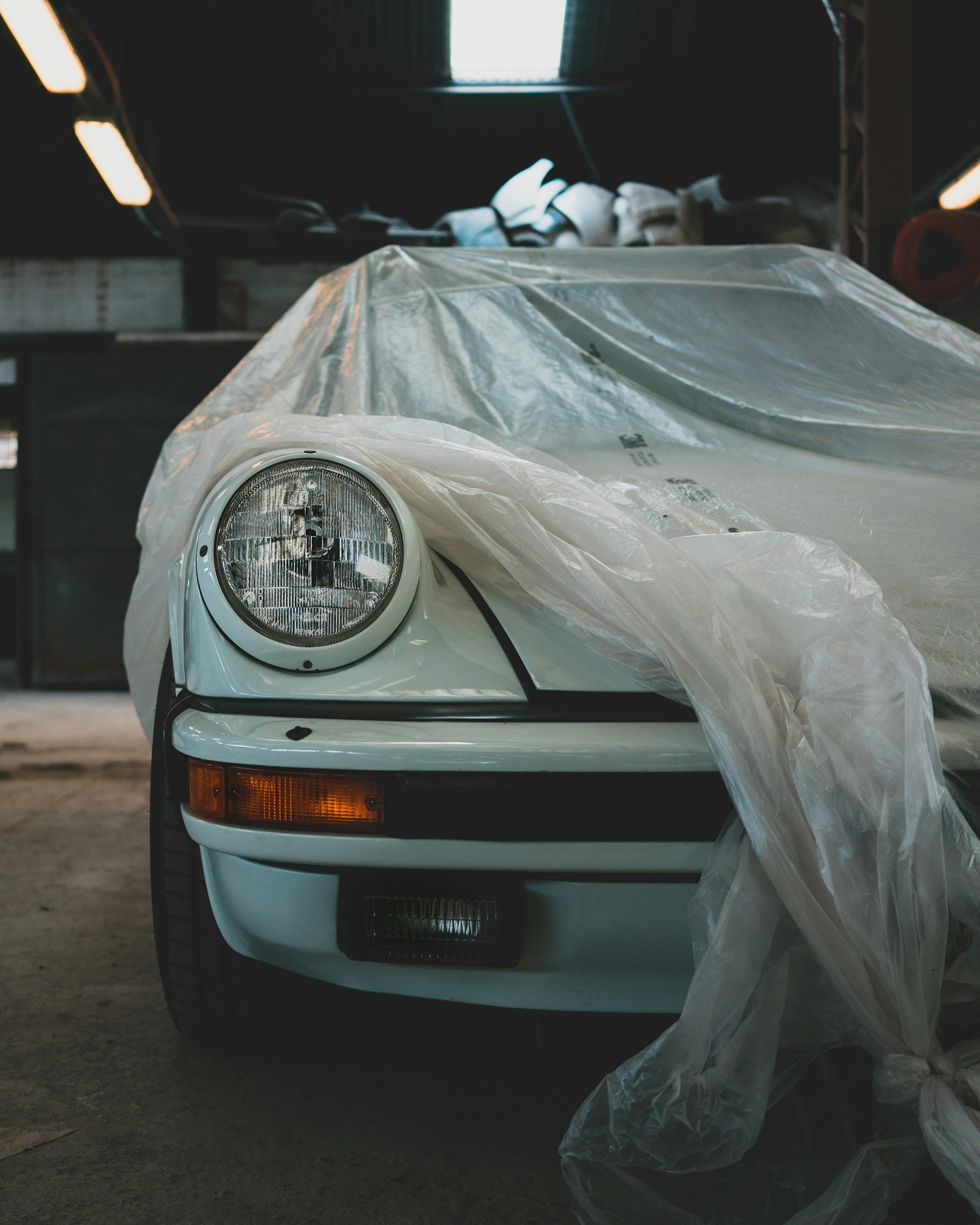 a white car covered in plastic in a garage
