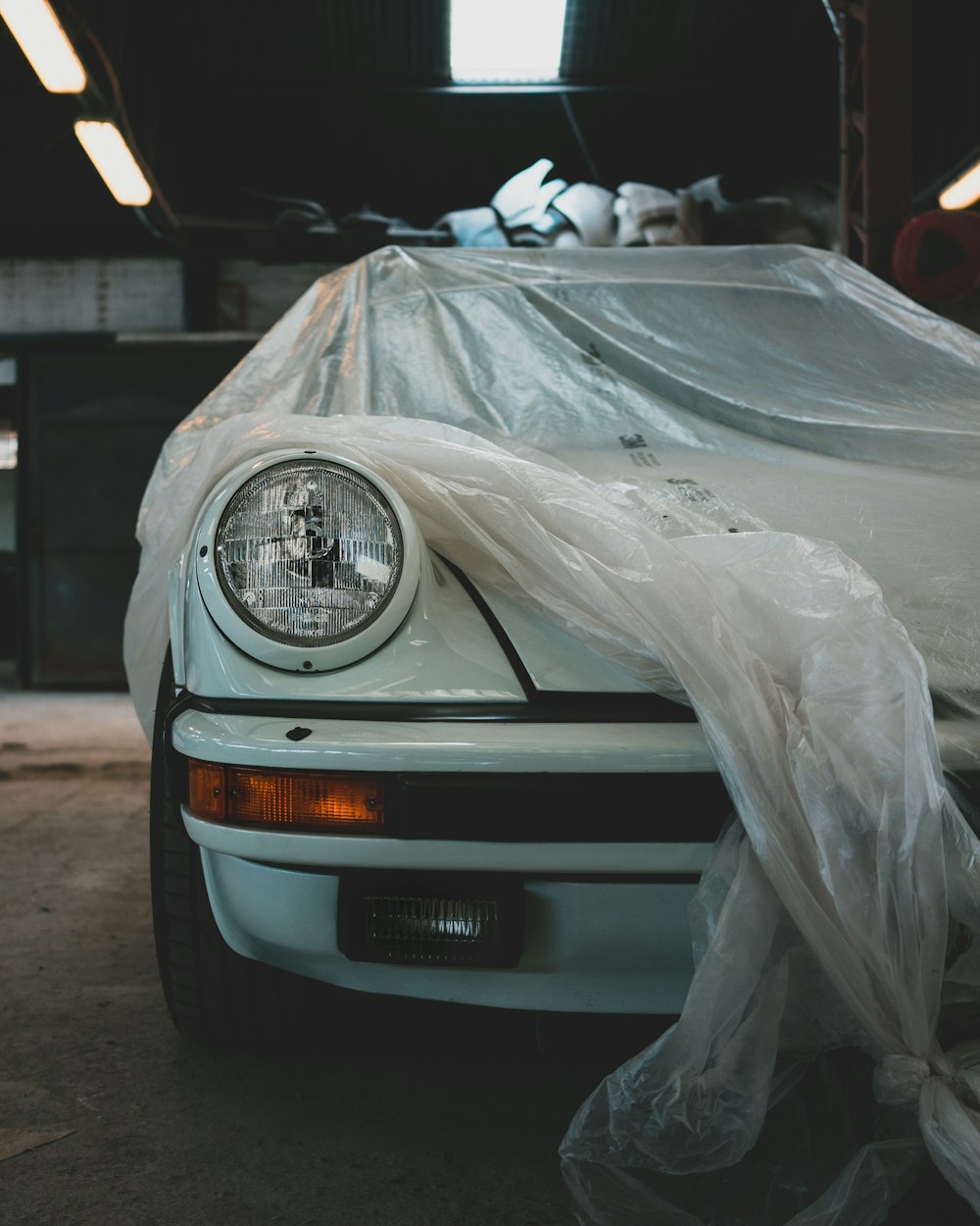 Ein weißes, mit Plastik bedecktes Auto in einer Garage