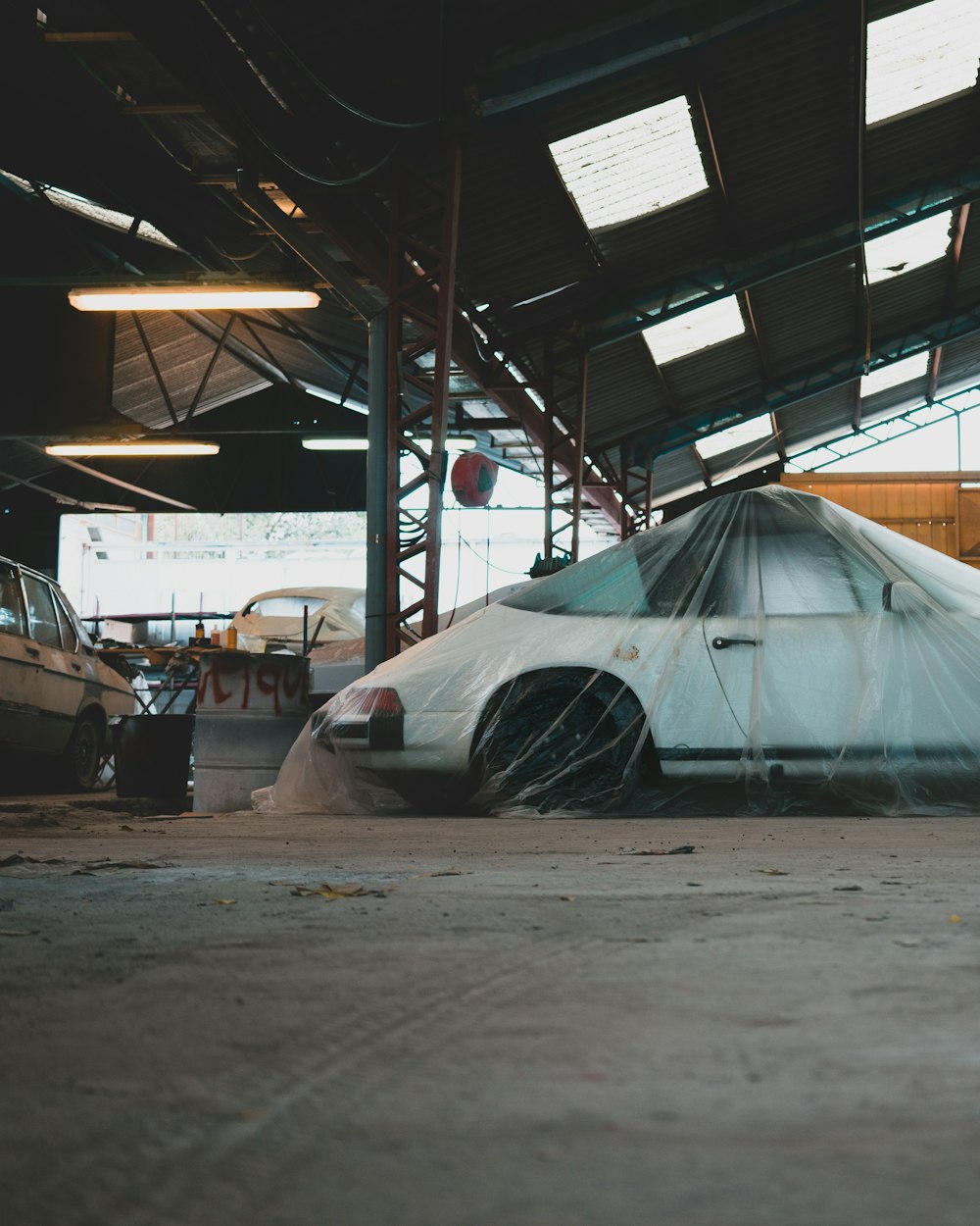 um carro coberto por uma lona em uma garagem