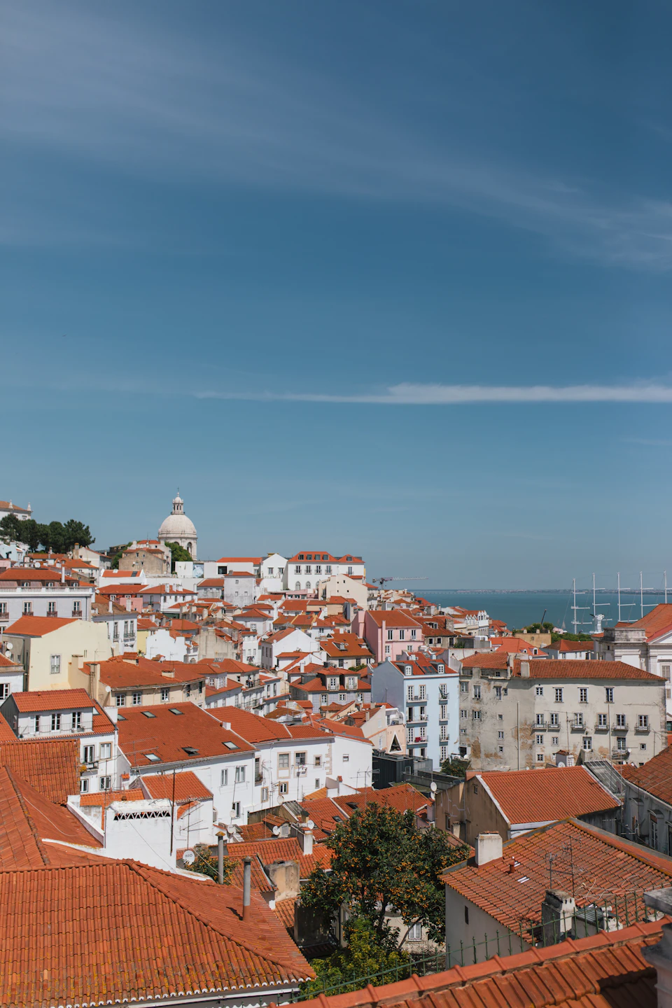Terracotta rooftops catch the low, golden light of a Lisbon autumn afternoon