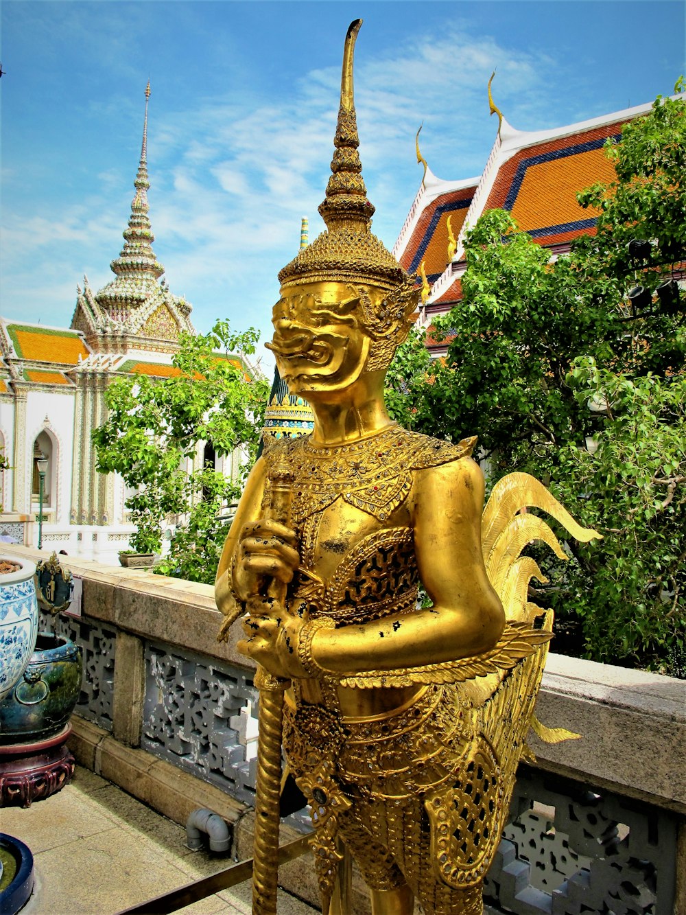 a golden statue of a person holding a staff