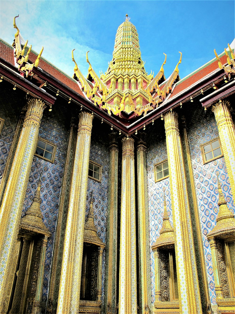 a gold and blue building with columns and a clock tower