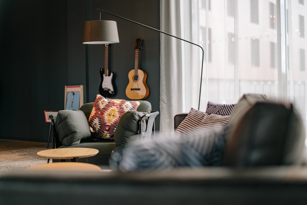 a living room filled with furniture and a guitar on the wall