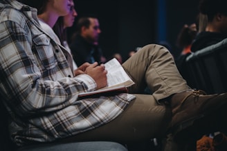 a man sitting in a chair with a book in his lap
