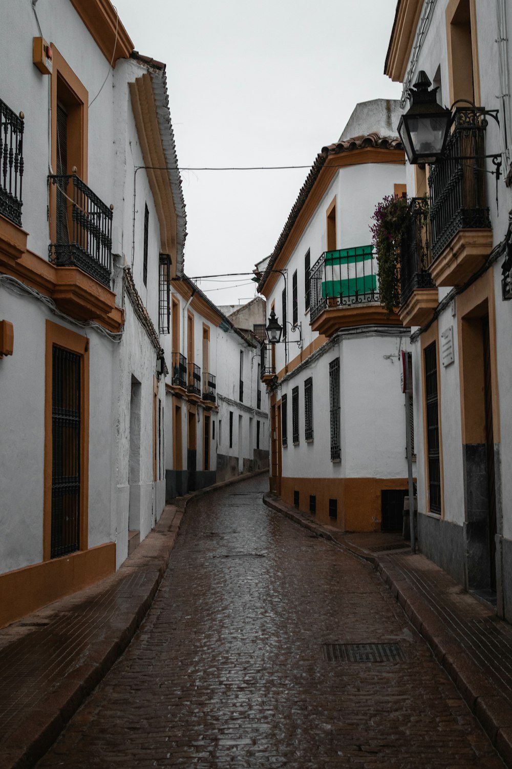 a narrow street with white and brown buildings