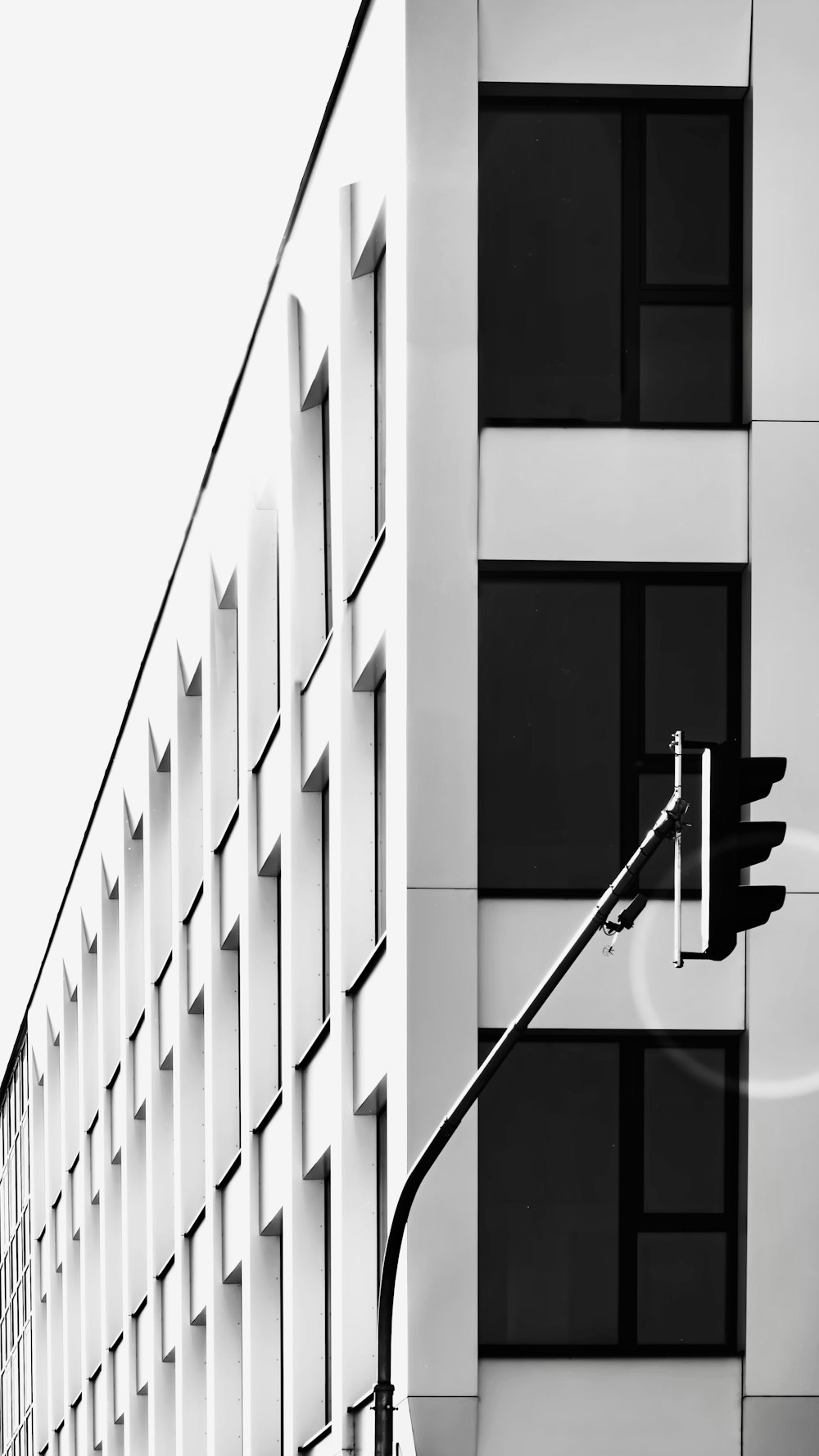 a black and white photo of a building with a traffic light