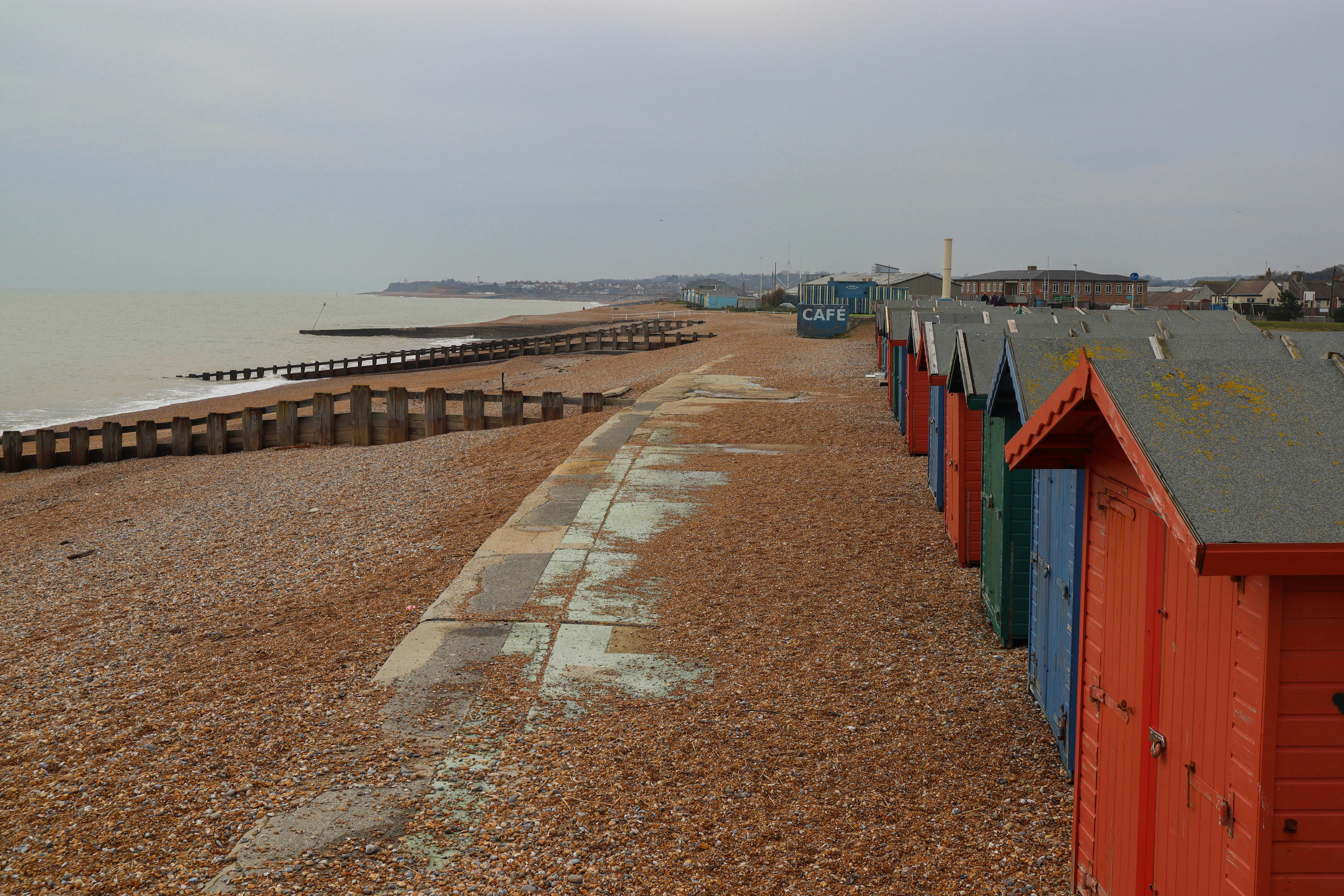 a row of beach huts sitting on top of a sandy beach
