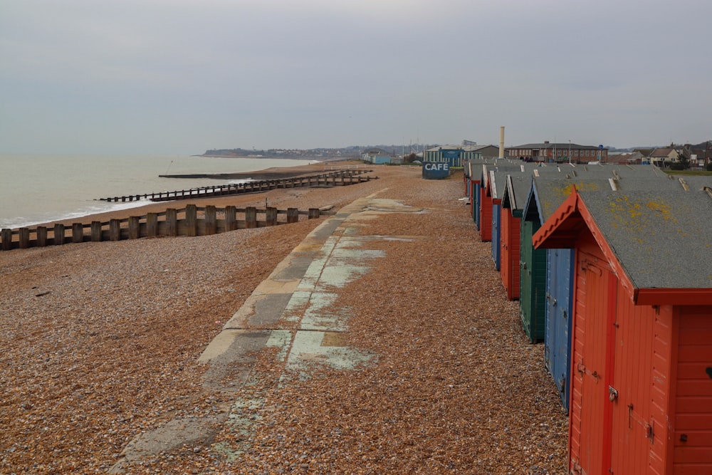 a row of beach huts sitting on top of a sandy beach