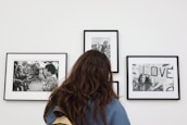 a woman looking at pictures on a wall