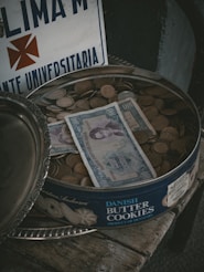 a bowl of money sitting on top of a wooden table