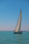 Yate Brisa sailing on calm turquoise waters under a bright sun.
