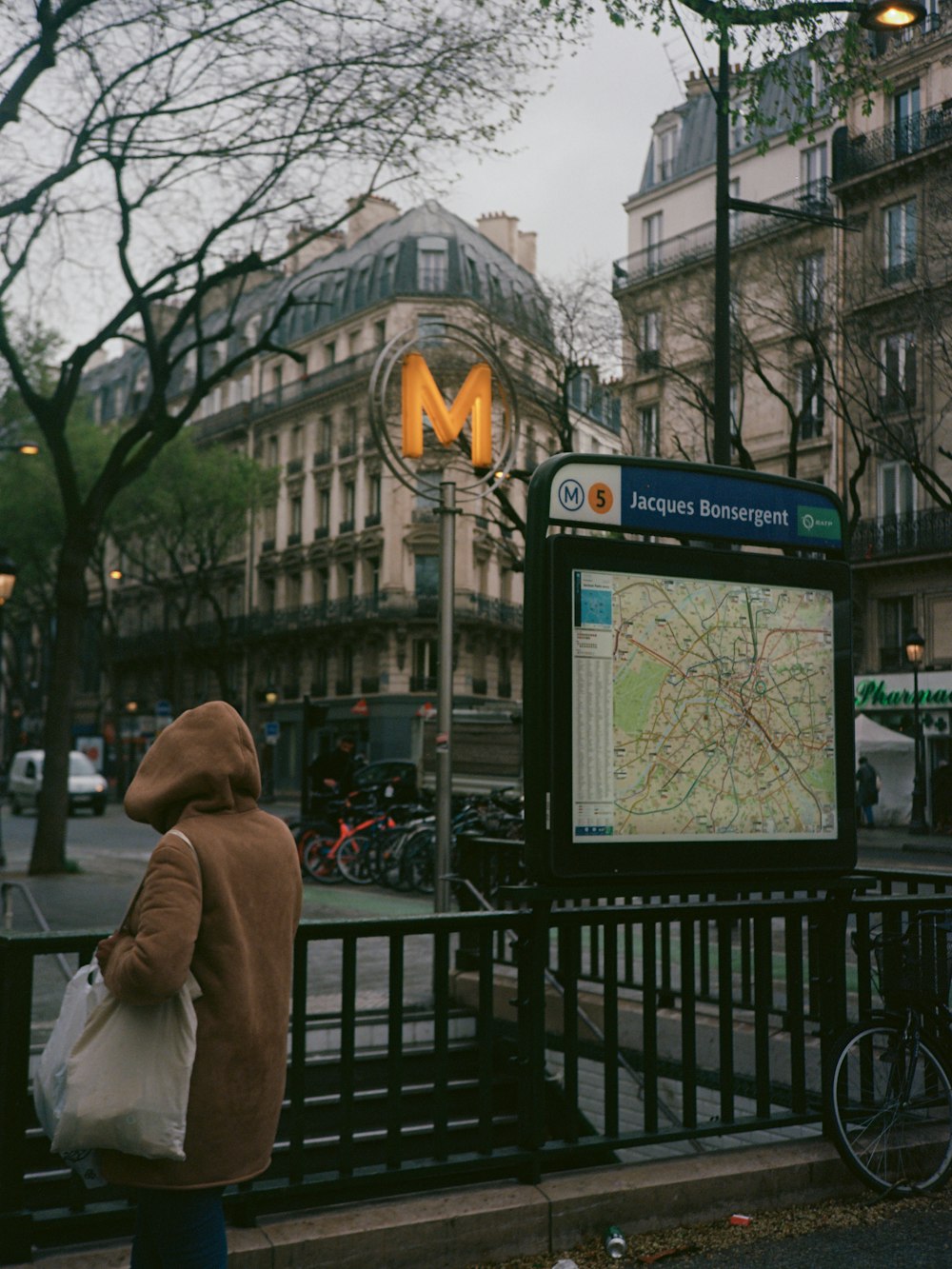 uma pessoa em uma jaqueta marrom está olhando para um mapa