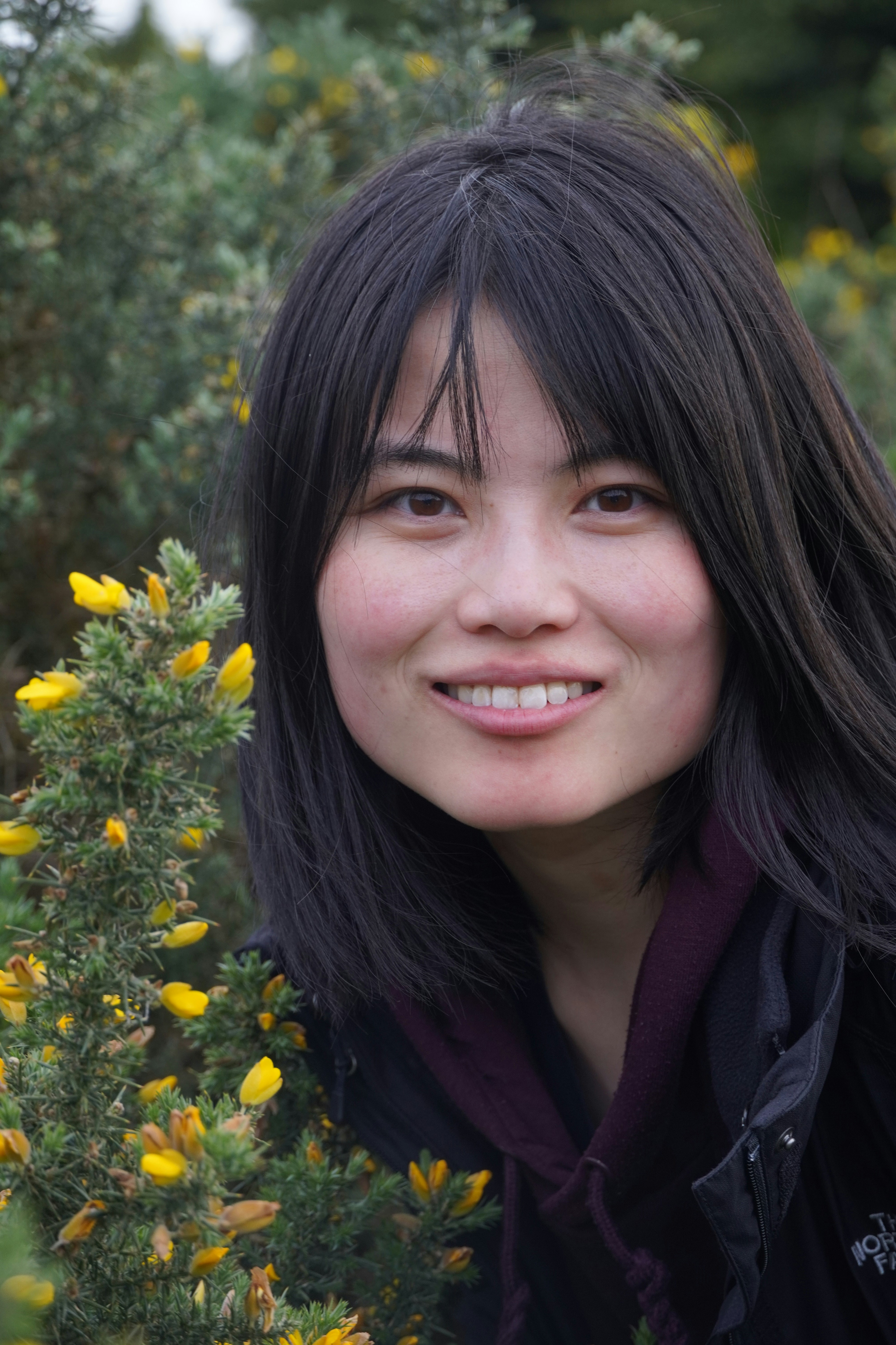 Happy woman smiling outdoors in bright sunlight