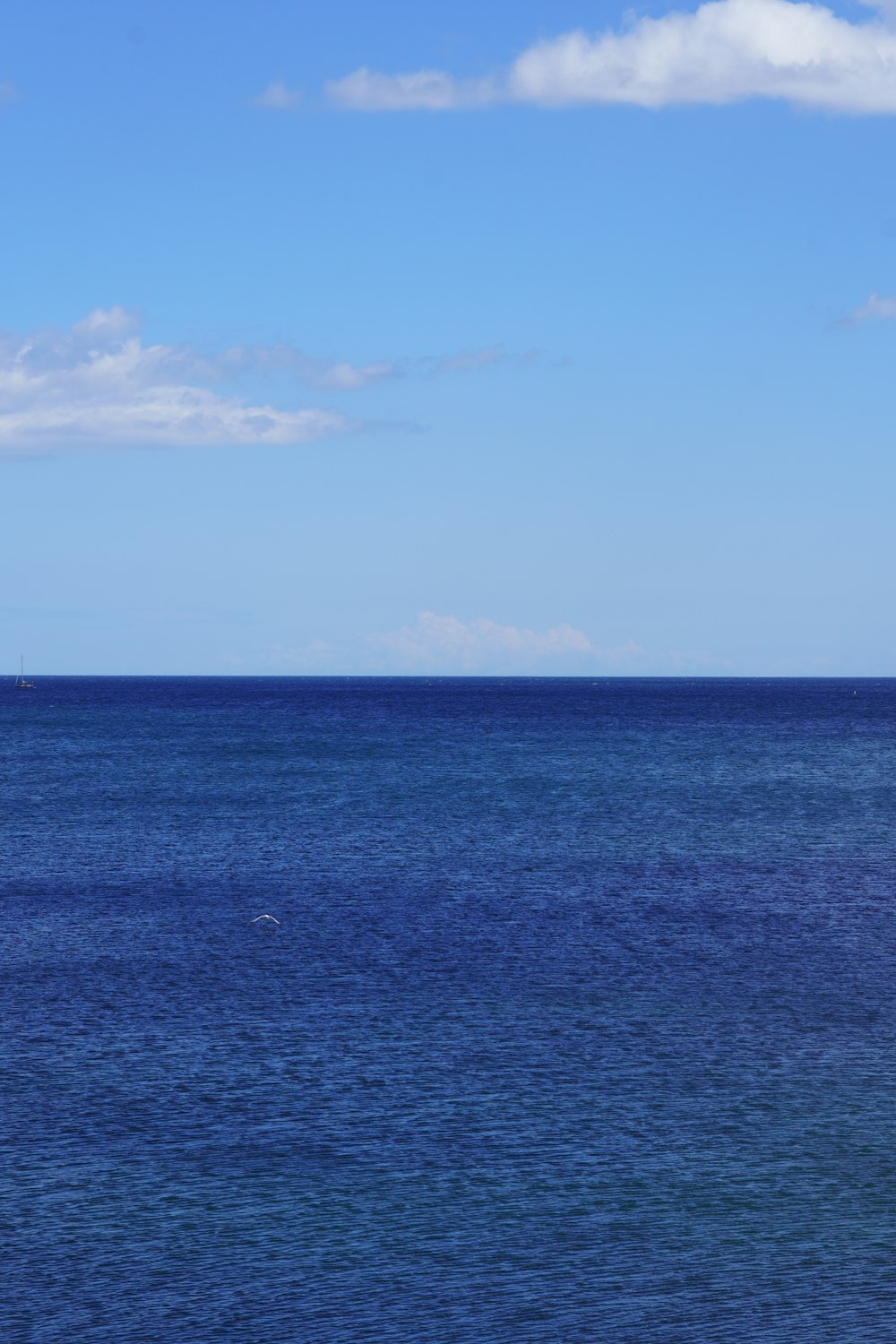 a lone boat floating in the middle of the ocean