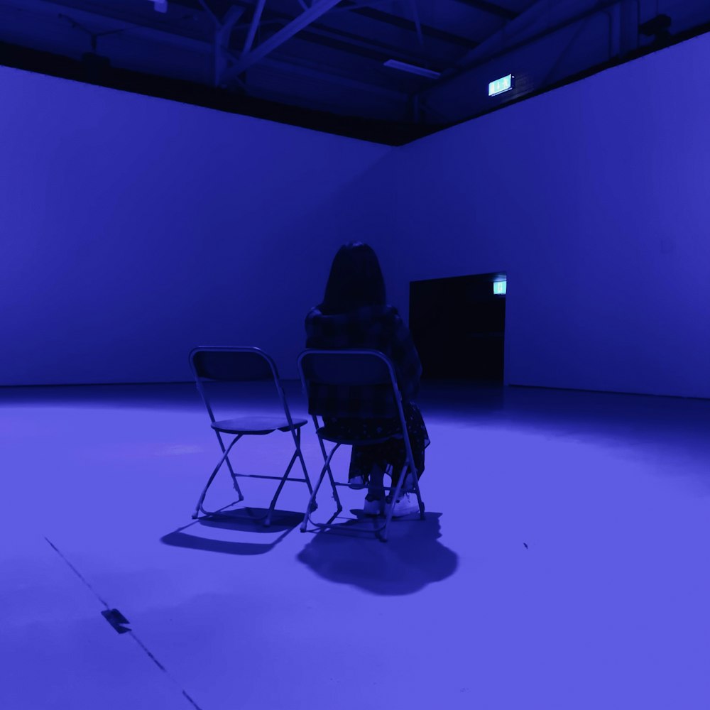 a person sitting in a chair in a dark room