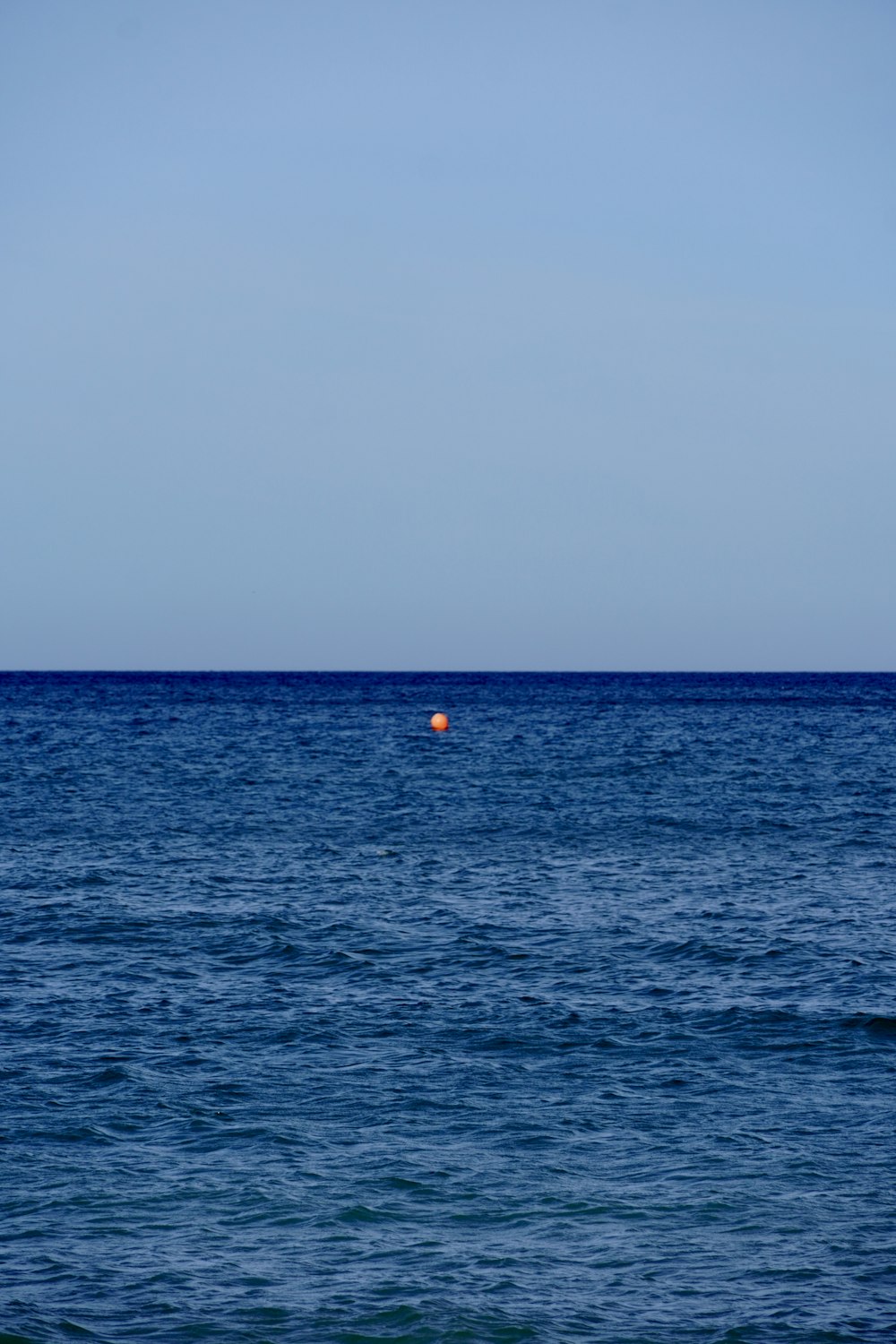 Una boa arancione che galleggia in mezzo all'oceano