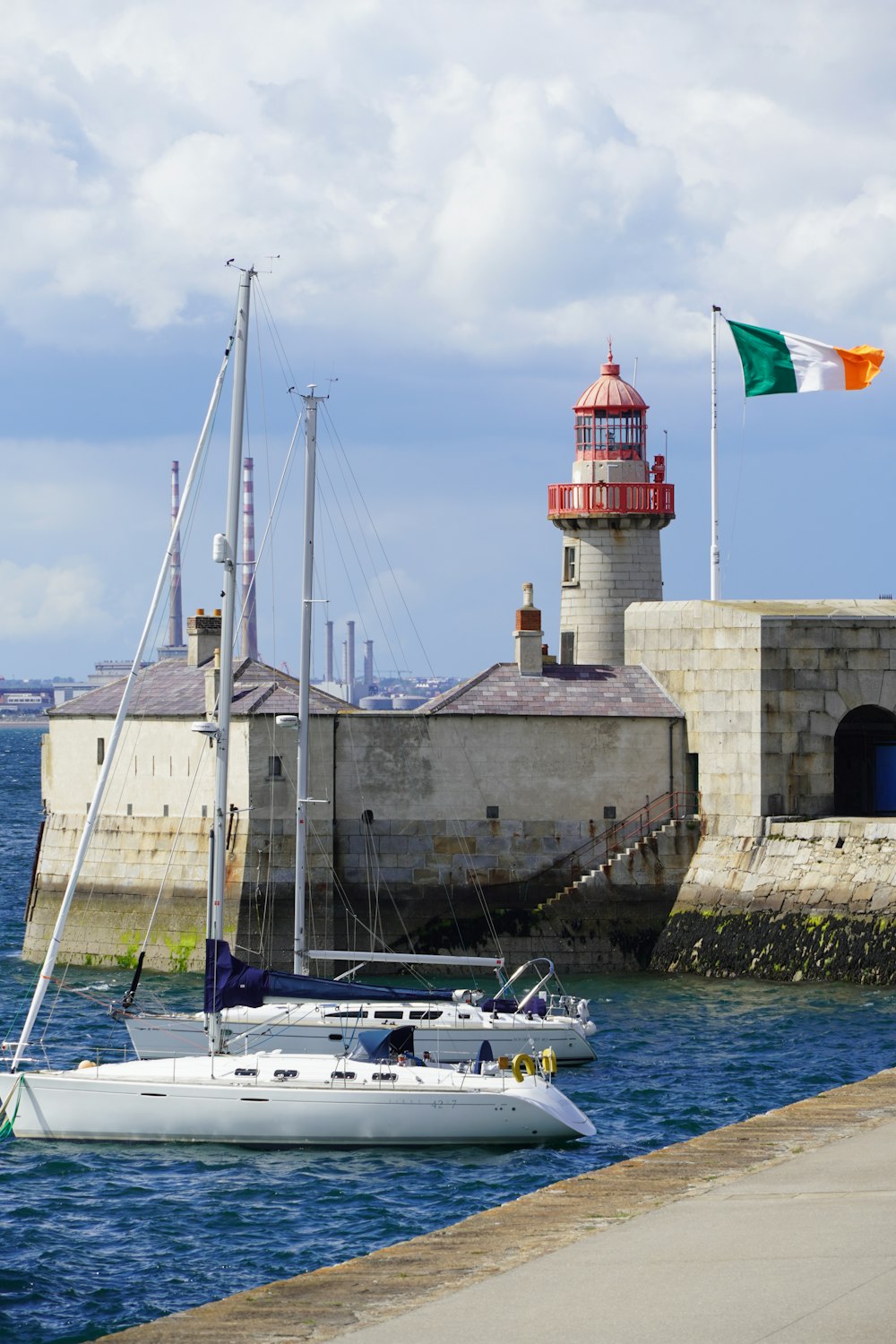 a sailboat in the water near a lighthouse