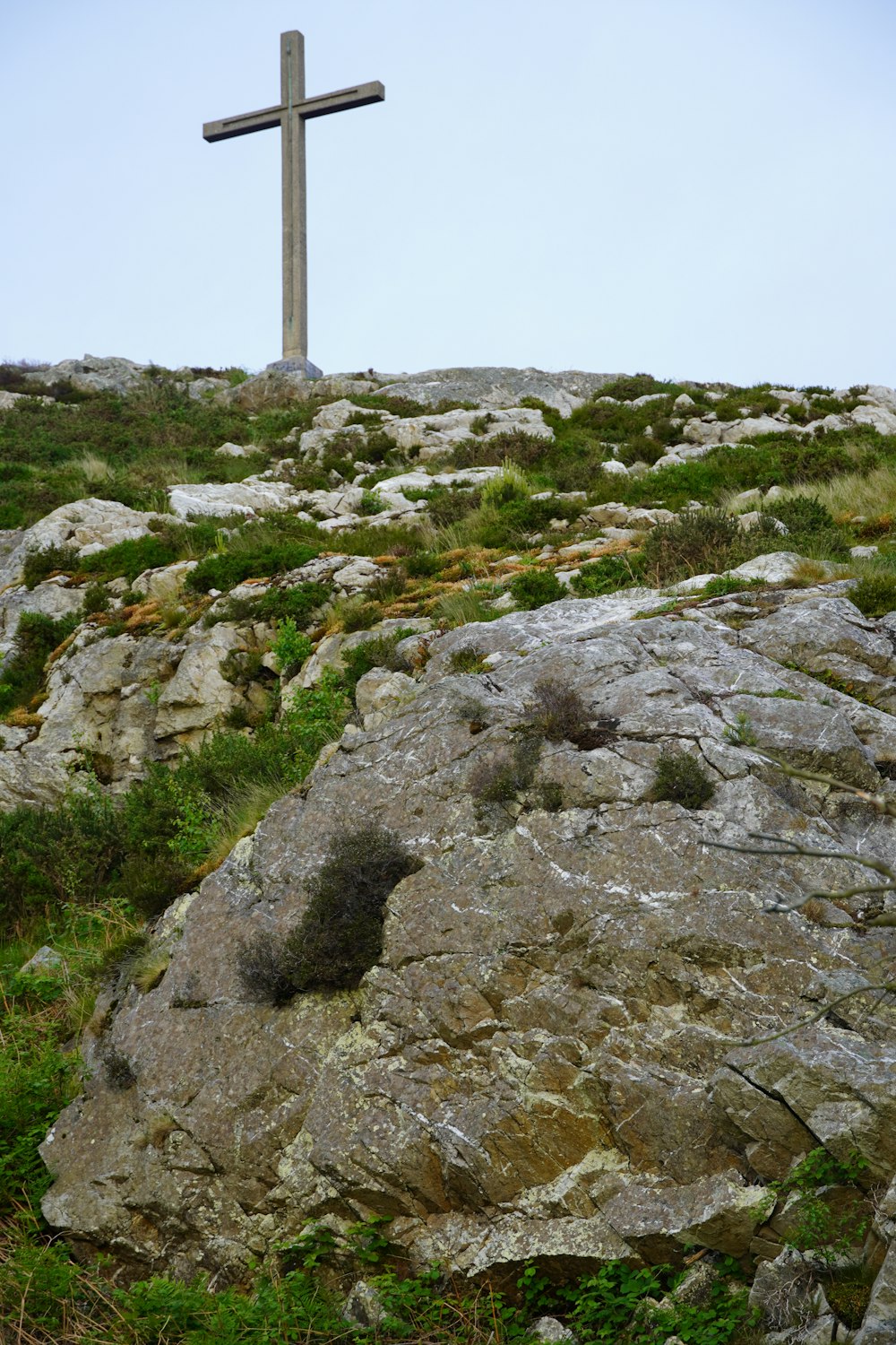 a cross on top of a rocky hill