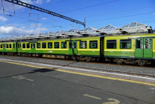 A green regional train at a station