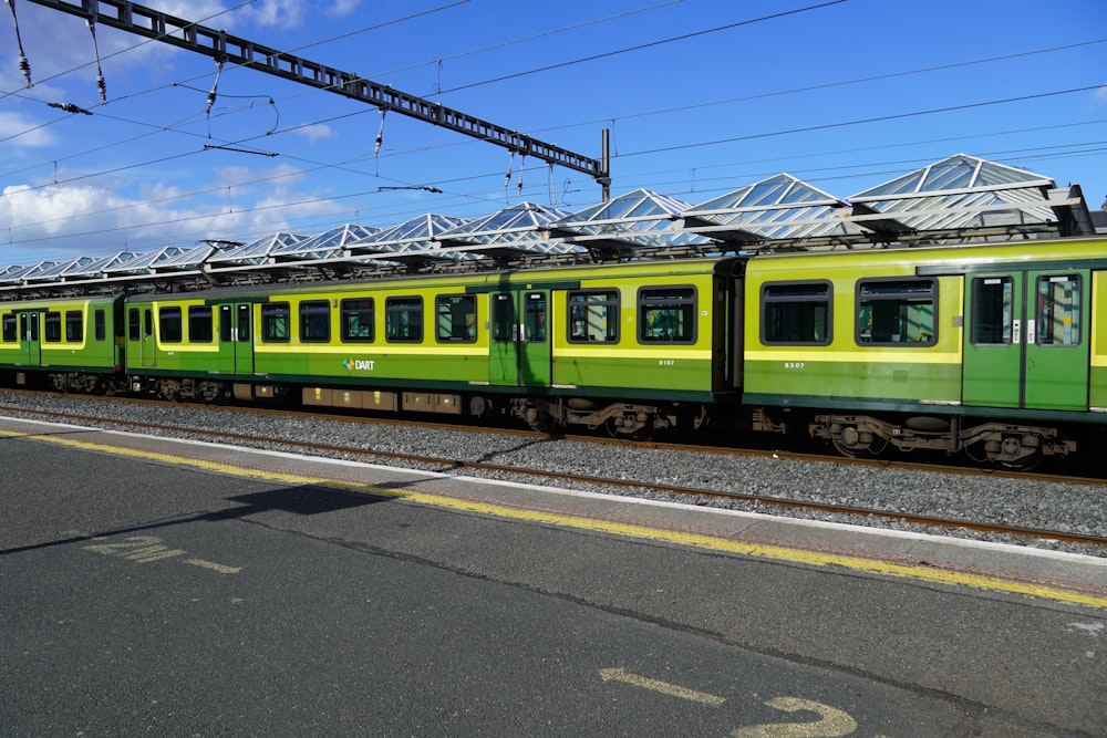 a green and yellow train traveling down train tracks