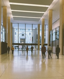 a group of people walking through a lobby